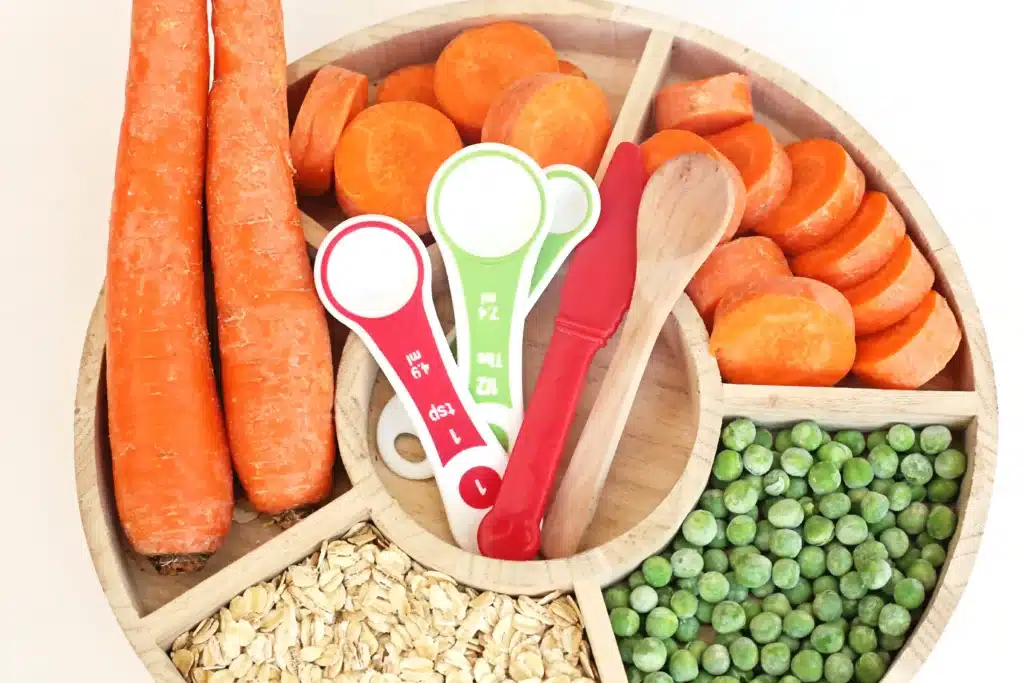 Reindeer Bait Sensory Bin - Cultivating Brilliant Minds a reindeer sensory bin filled with rolled oats, sliced carrots, and peas