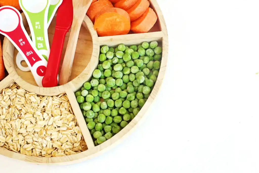 Reindeer Bait Sensory Bin - Cultivating Brilliant Minds a reindeer sensory bin filled with rolled oats, sliced carrots, and peas