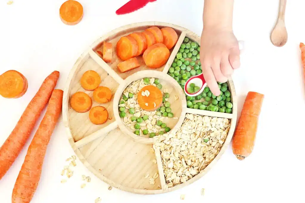 Reindeer Bait Sensory Bin - Cultivating Brilliant Minds a reindeer sensory bin filled with rolled oats, sliced carrots, and peas