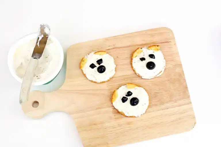 crackers with cream cheese and olives to look like a polar bear