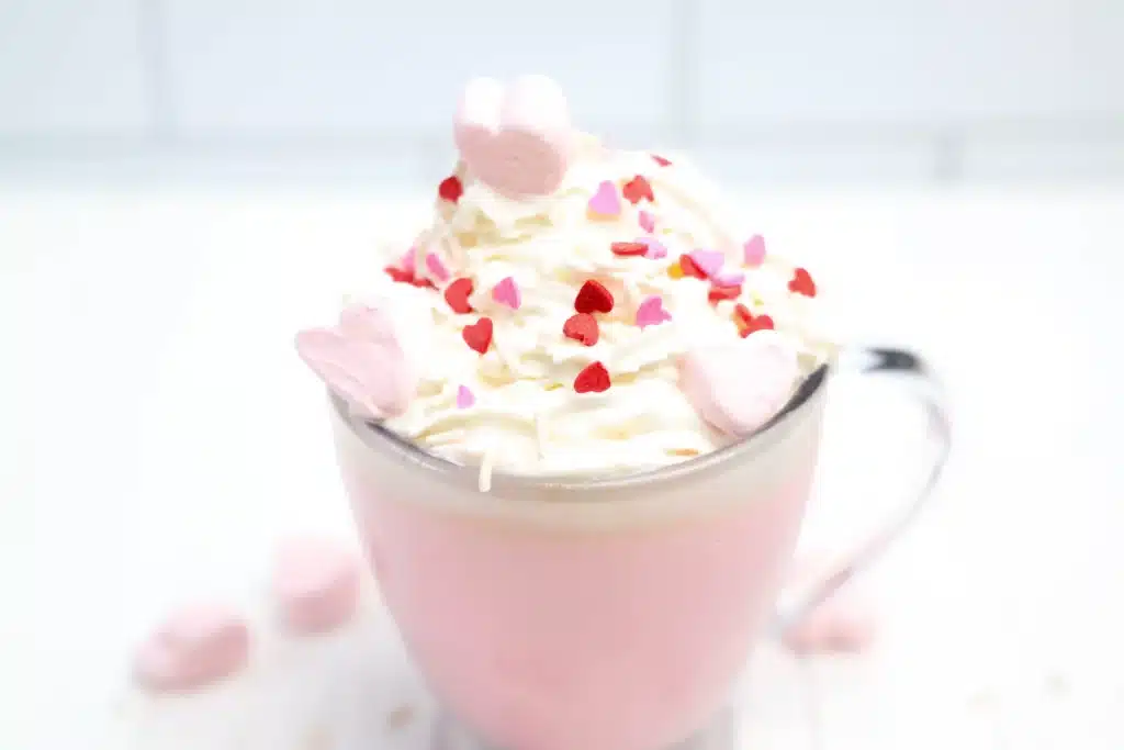 Strawberry White Hot Chocolate - Cultivating Brilliant Minds strawberry white hot chocolate with whipped cream and heart sprinkles