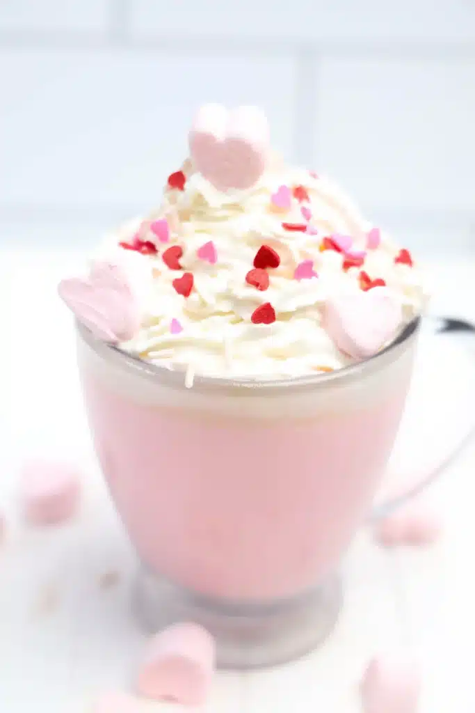 Strawberry White Hot Chocolate - Cultivating Brilliant Minds strawberry white hot chocolate with whipped cream and heart sprinkles