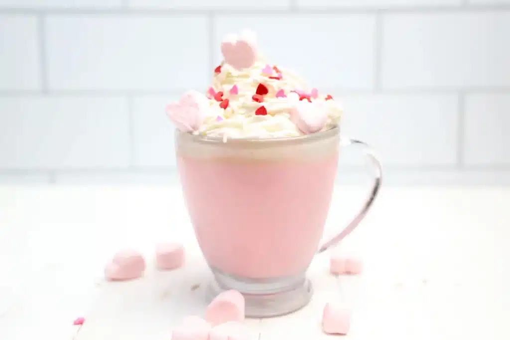 Strawberry White Hot Chocolate - Cultivating Brilliant Minds strawberry white hot chocolate with whipped cream and heart sprinkles