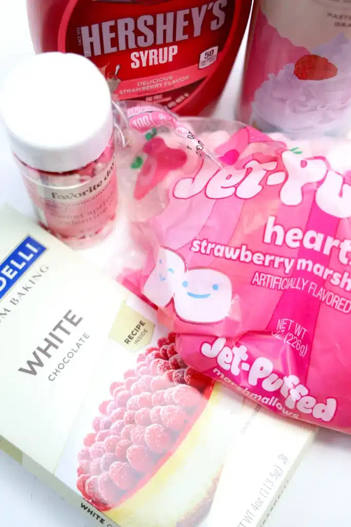 Strawberry White Hot Chocolate - Cultivating Brilliant Minds white chocolate, pink marshmallows, whipped cream, strawberry syrup, and heart sprinkles