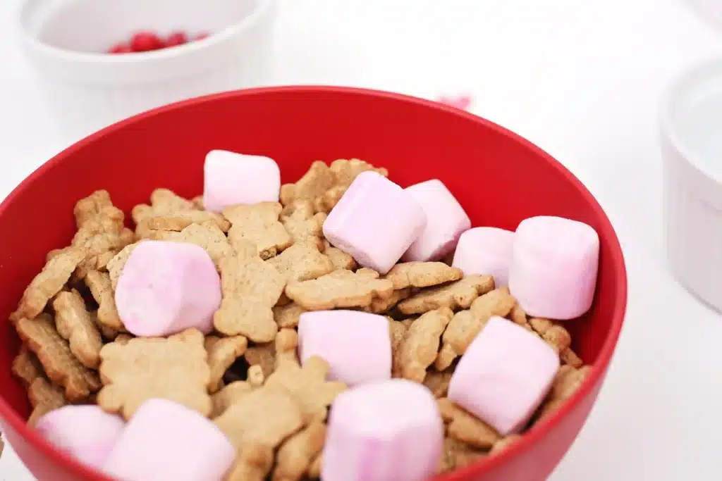 Valentine's Day Cupid Snack Mix - Cultivating Brilliant Minds teddy grahams and pink marshmallows in a red bowl