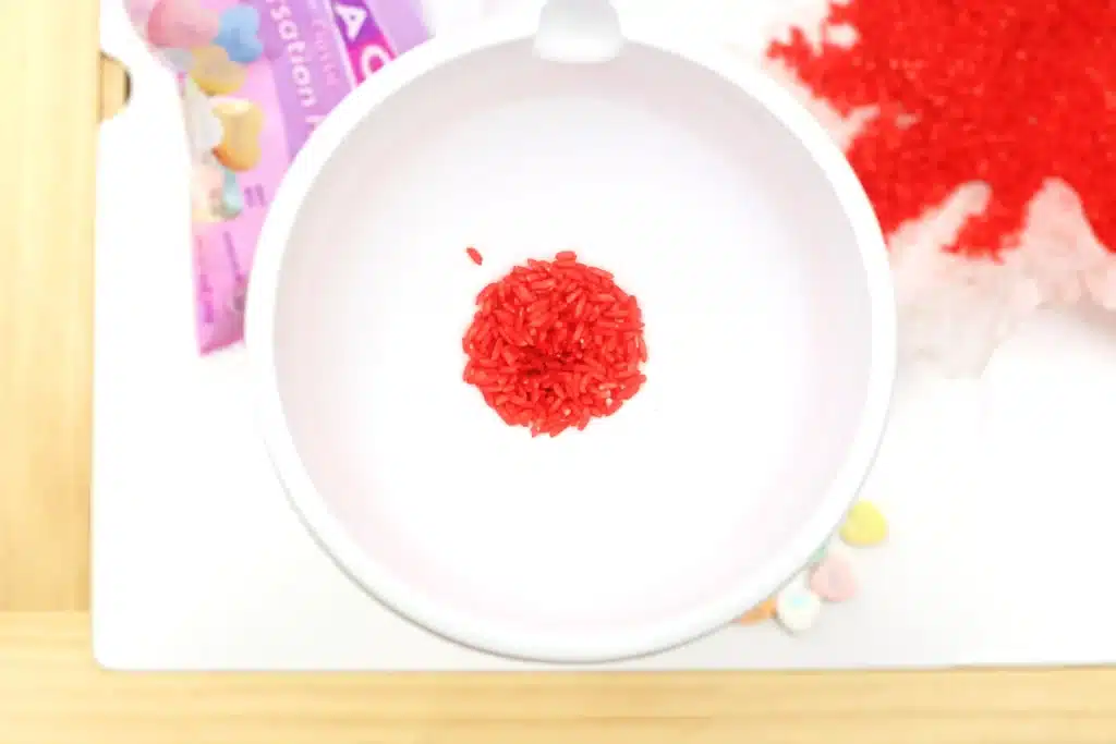 Valentine's Day Candy Heart Sensory Bottle - Cultivating Brilliant Minds red dyed rice on a plate