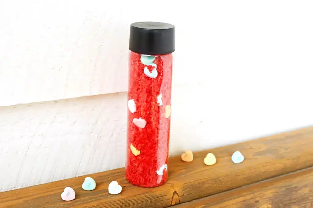 Valentine's Day Candy Heart Sensory Bottle - Cultivating Brilliant Minds a candy heart sensory bottle that uses red rice and candy hearts