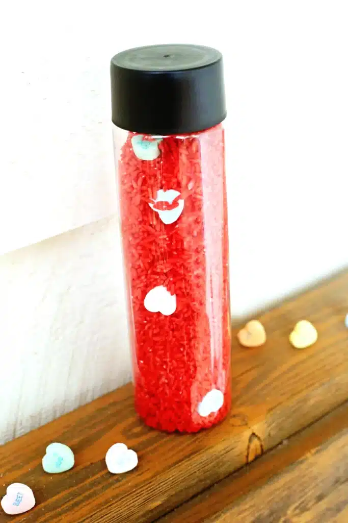 Valentine's Day Candy Heart Sensory Bottle - Cultivating Brilliant Minds a candy heart sensory bottle that uses red rice and candy hearts