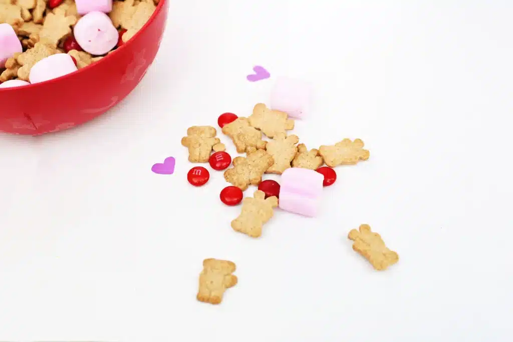 Valentine's Day Cupid Snack Mix - Cultivating Brilliant Minds pink marshmallows, red m&ms and teddy grahams on a white table