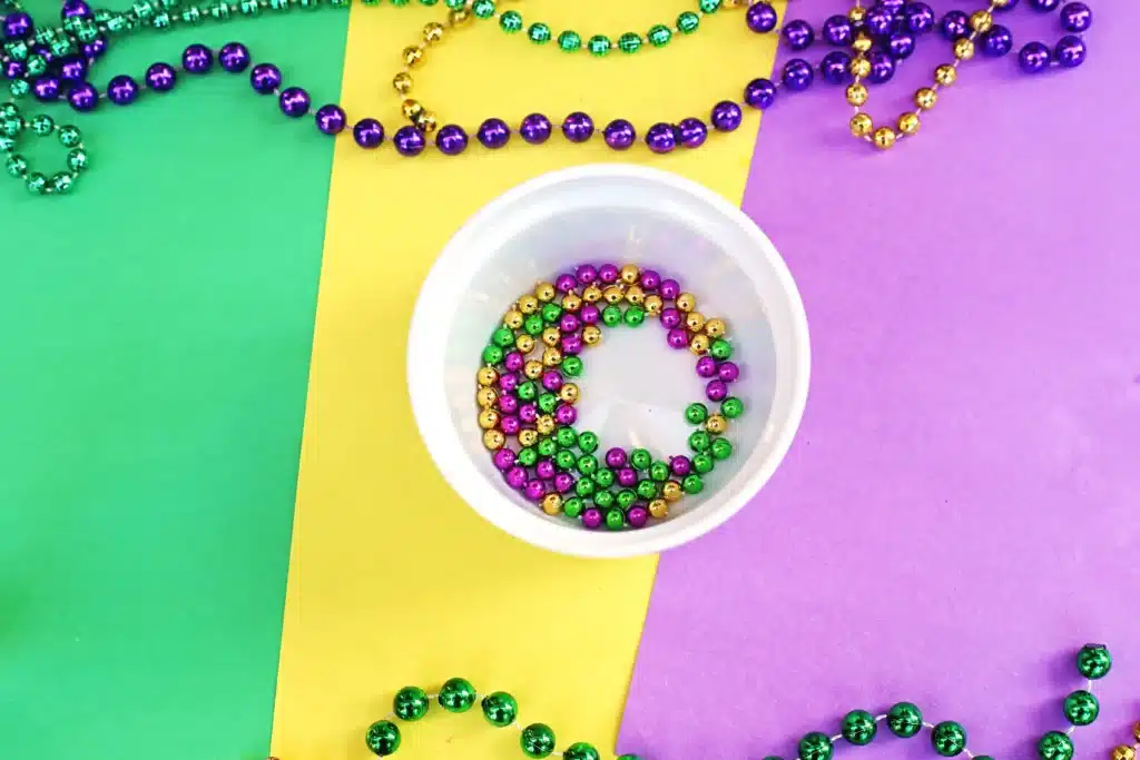 Mardi Gras Sensory Bottle - Cultivating Brilliant Minds a cut mardi gras beaded necklace