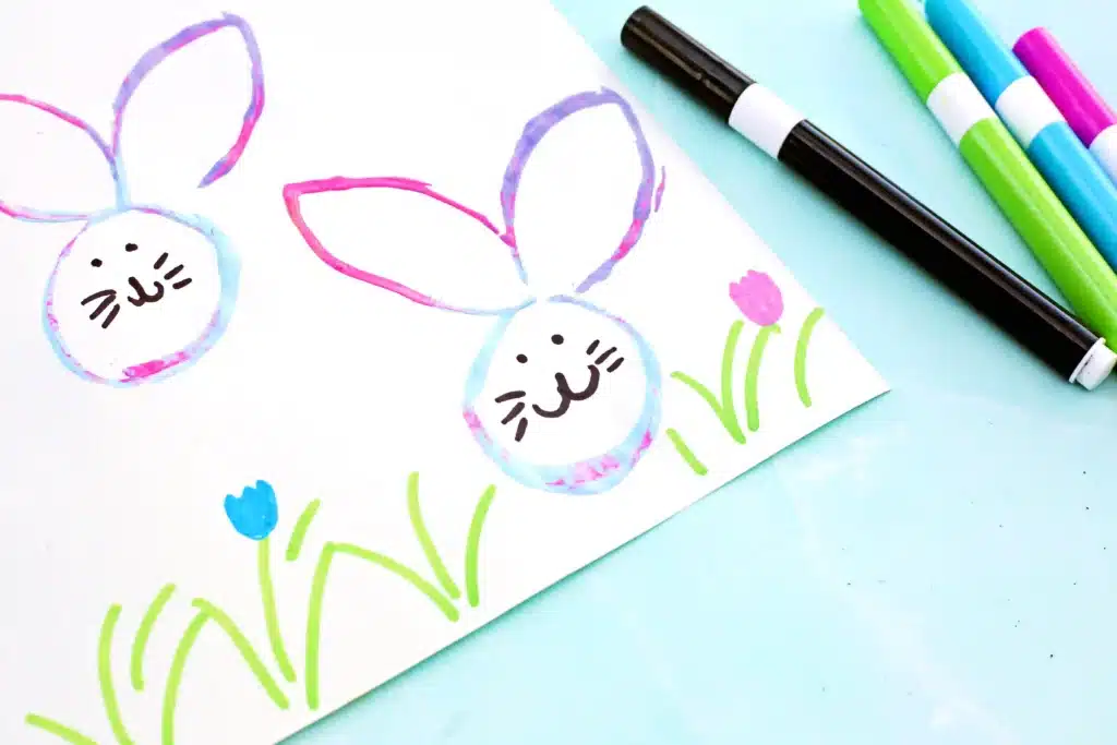 Bunny Stamp Art with Toilet Paper Rolls - Cultivating Brilliant Minds bunny stamp art on a piece of paper using a toilet paper roll with a face drawn on in black marker