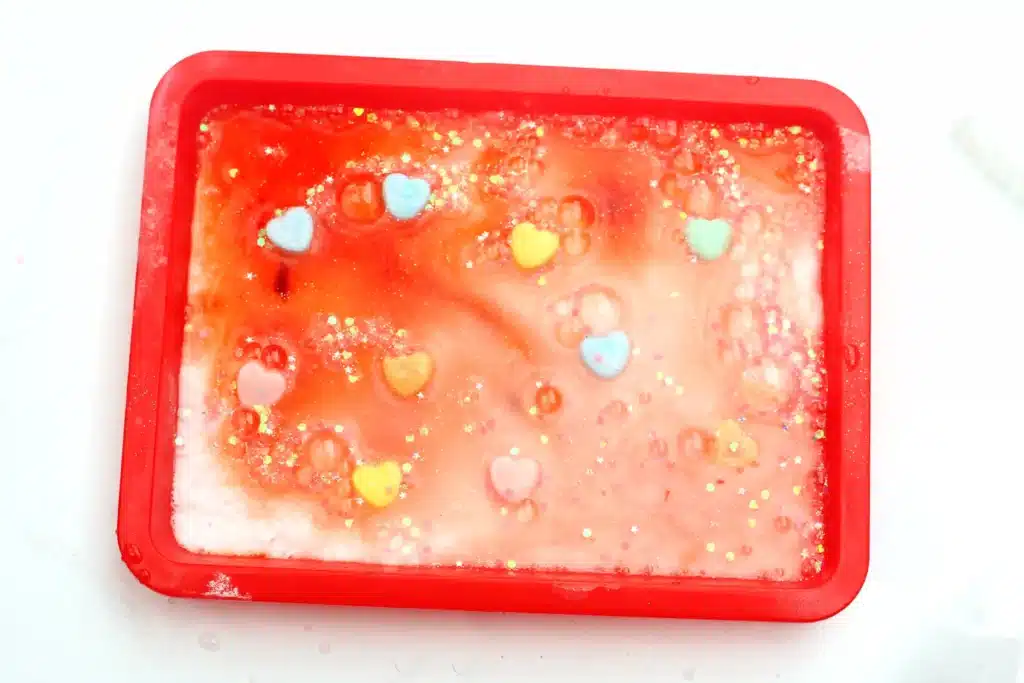 Valentine's Day Fizzy Candy Hearts Experiment - Cultivating Brilliant Minds valentine's day stem activity with vinegar poured over candy hearts with baking soda on them to make them fizz
