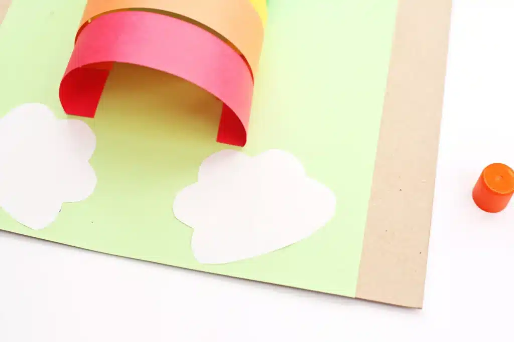 DIY Paper Leprechaun Trap STEM Craft - Cultivating Brilliant Minds white construction paper cut into a cloud shape and glued next to the rainbow arch