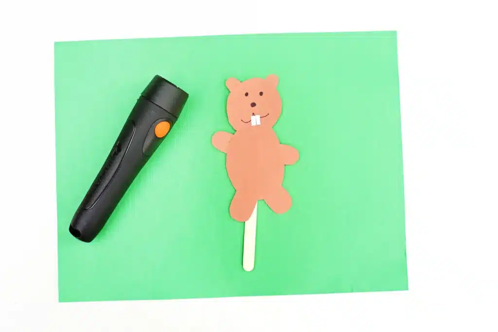 Groundhog Day Shadow Experiment - Cultivating Brilliant Minds a groundhog made out of construction paper glued to a popsicle stick next to a flashlight