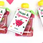 Printable Valentines: Hugs and squeezes - Cultivating Brilliant Minds printable non-candy valentines using a squeezable applesauce and a valentine that reads "hugs and kisses" and has an apple on it.
