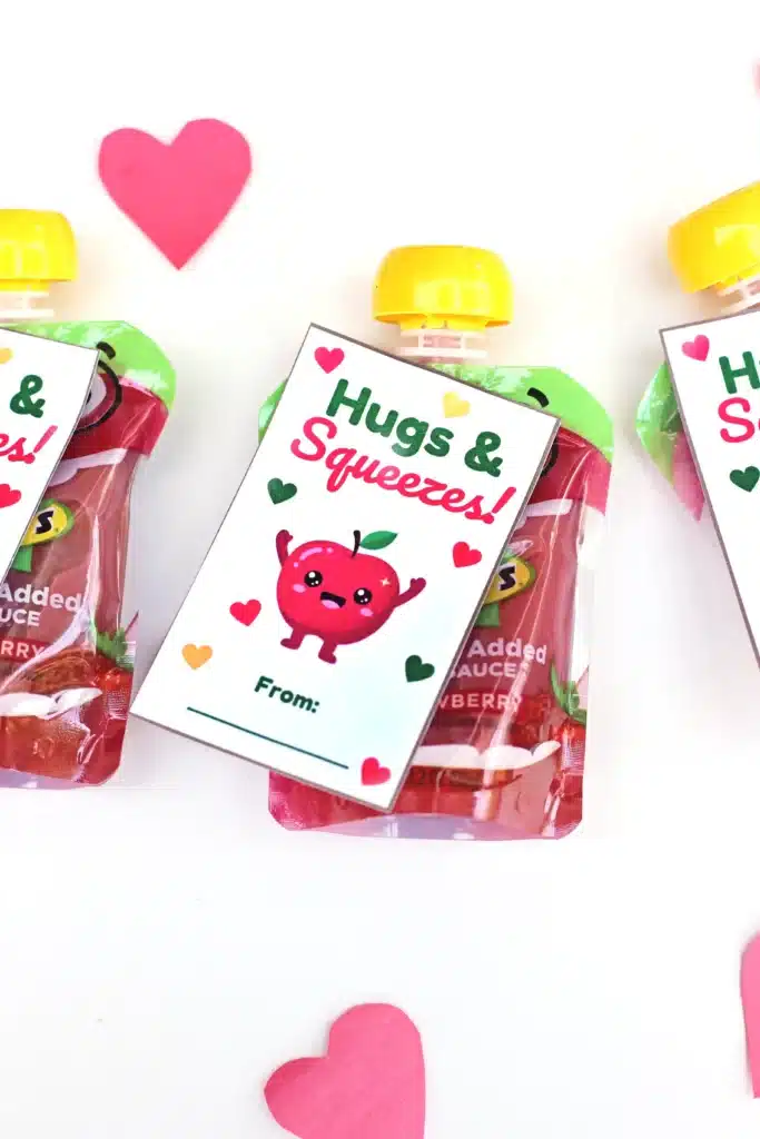Printable Valentines: Hugs and squeezes - Cultivating Brilliant Minds printable non-candy valentines using a squeezable applesauce and a valentine that reads "hugs and kisses" and has an apple on it.