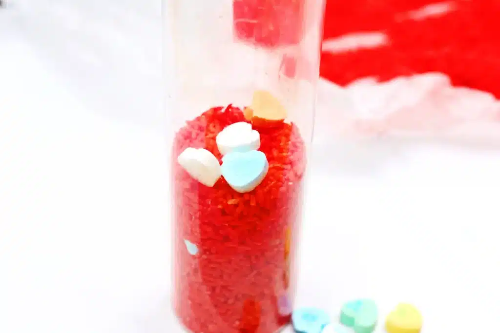 Valentine's Day Candy Heart Sensory Bottle - Cultivating Brilliant Minds a candy heart sensory bottle that uses red rice and candy hearts
