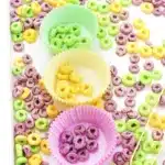 Mardi Gras Color Sorting Sensory Bin - Cultivating Brilliant Minds green, yellow, and purple froot loops separated by color in the corresponding color muffin liner