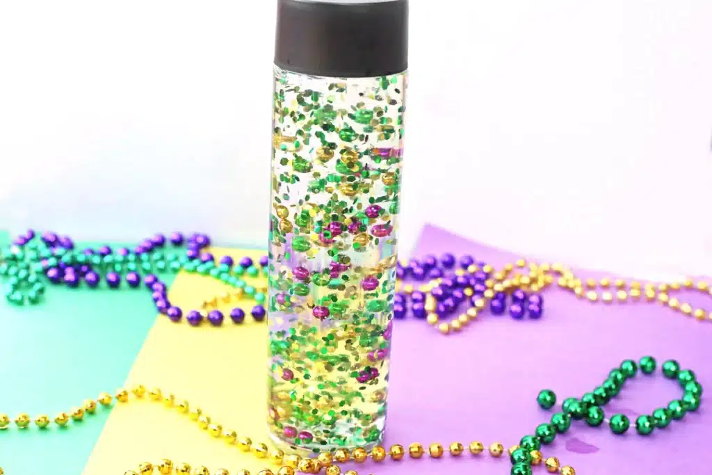 Mardi Gras Sensory Bottle - Cultivating Brilliant Minds a mardi gras sensory bottle that uses mardi gras beads and glitter in water
