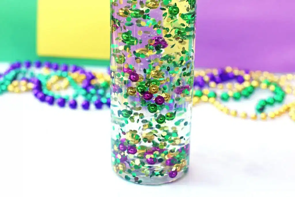 Mardi Gras Sensory Bottle - Cultivating Brilliant Minds a mardi gras sensory bottle that uses mardi gras beads and glitter in water