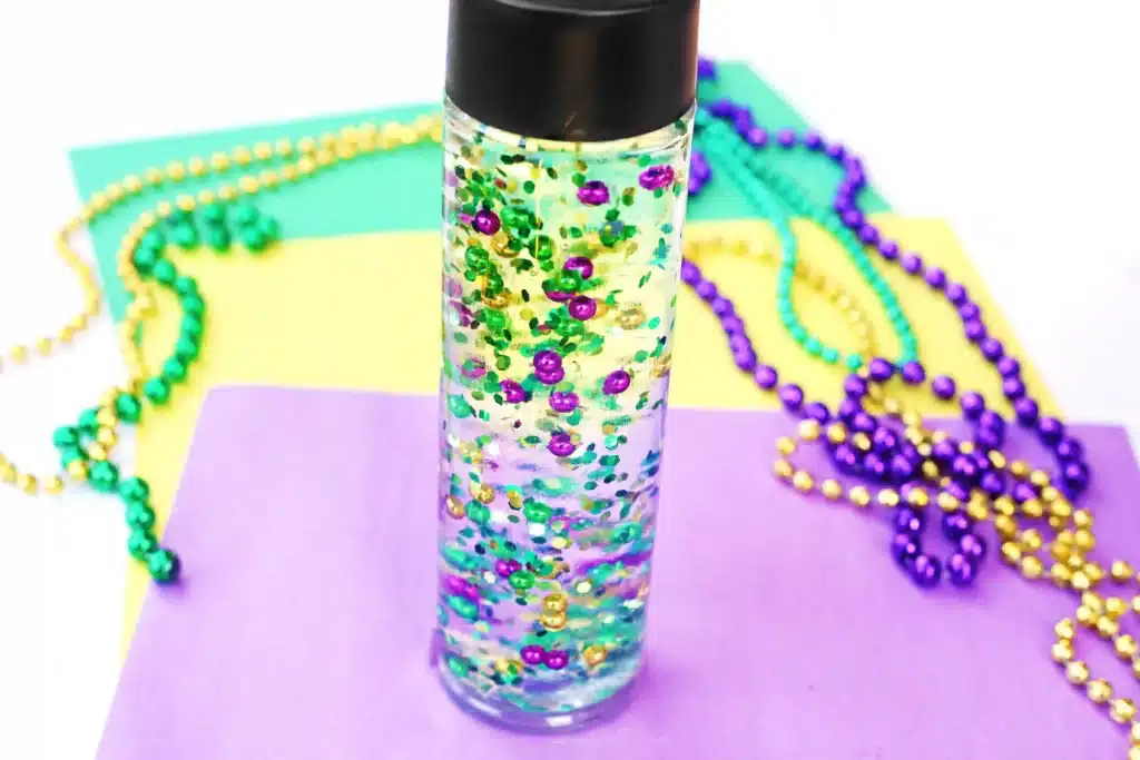 Mardi Gras Sensory Bottle - Cultivating Brilliant Minds a mardi gras sensory bottle that uses mardi gras beads and glitter in water