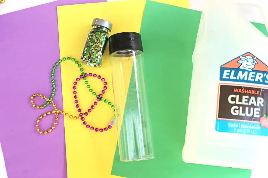 Mardi Gras Sensory Bottle - Cultivating Brilliant Minds mardi gras beads, glitter, and an empty water bottle