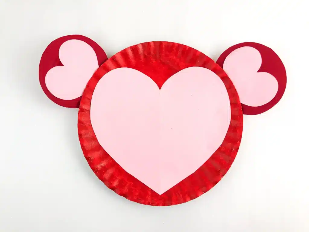 Valentine Monkey Craft - Cultivating Brilliant Minds a paper plate painted red with red ears and a heart on the plate