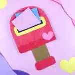 Valentine's Day Mailbox Paper Plate Craft - Cultivating Brilliant Minds a paper plate painted pink and cut into the shape of a mailbox with a slot cut in the middle for mail.