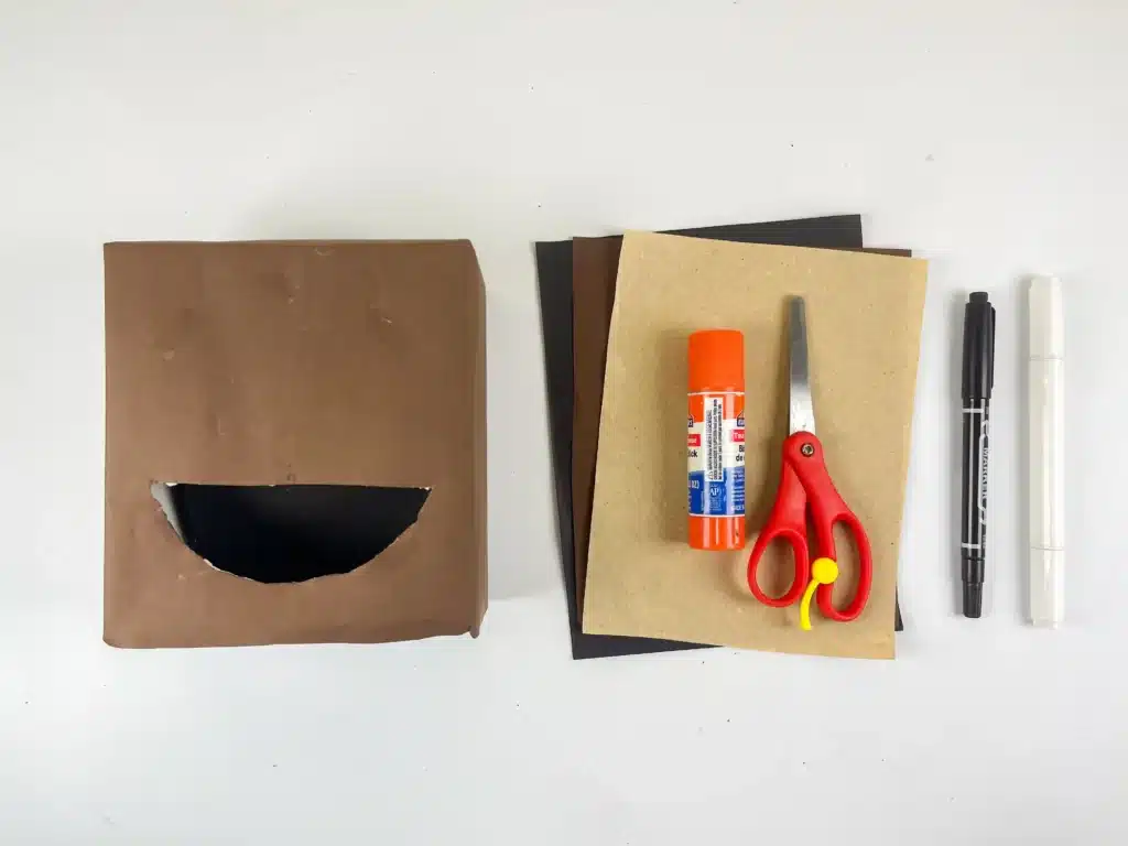 Sloth Valentine Box - Cultivating Brilliant Minds a box covered in brown paper, brown and tan colored construction paper, scissors, glue, and a black marker