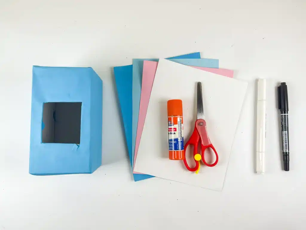 Hippo Valentine Box - Cultivating Brilliant Minds a box covered in blue paper. colored construction paper, glue, scissors, and a black marker