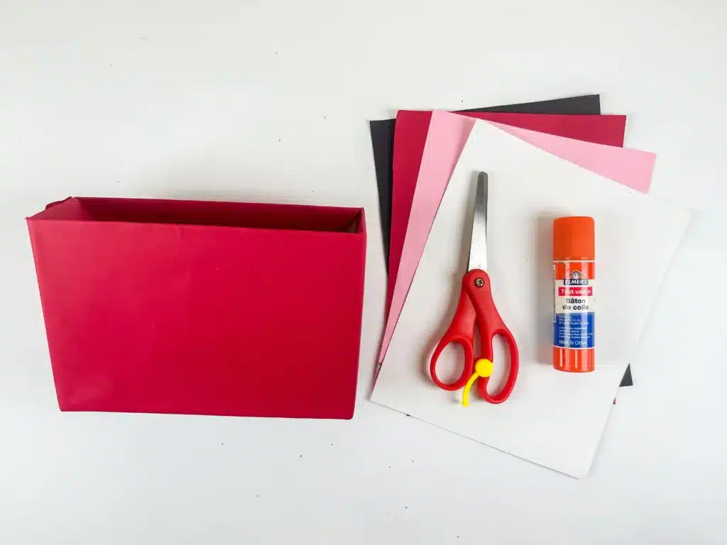 DIY Ladybug Valentine Box - Cultivating Brilliant Minds a cardboard box covered in red paper, colored construction paper, scissors, and glue