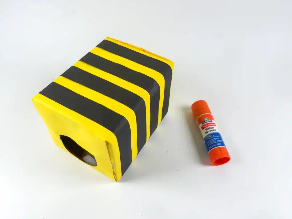Bee Valentines Box - Cultivating Brilliant Minds a box covered in yellow paper with black strips of paper glued on to make stripes