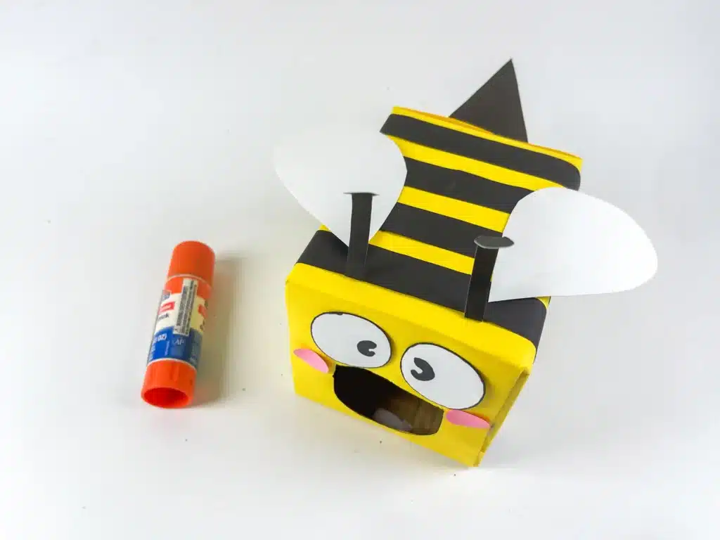 Bee Valentines Box - Cultivating Brilliant Minds bee valentines box that has a box wrapped in yellow paper with black stripes and a construction paper face, wings, and antennae