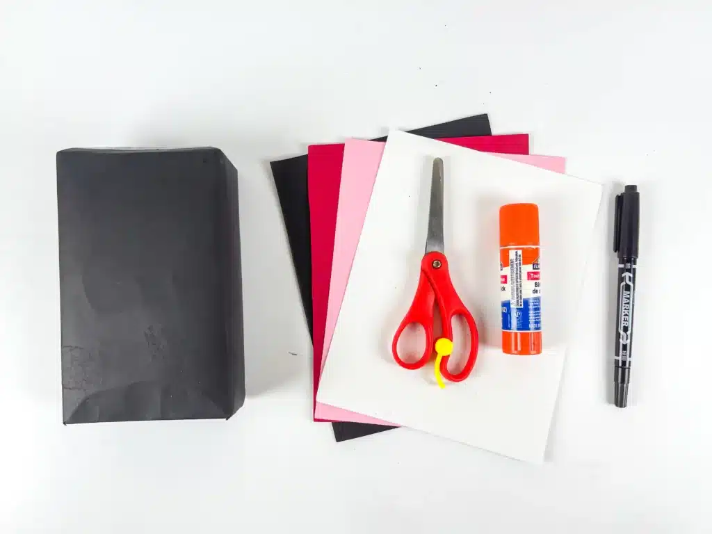 Ladybug Valentines Box - Cultivating Brilliant Minds a box covered in black paper, colored construction paper, scissors, glue, and a black marker