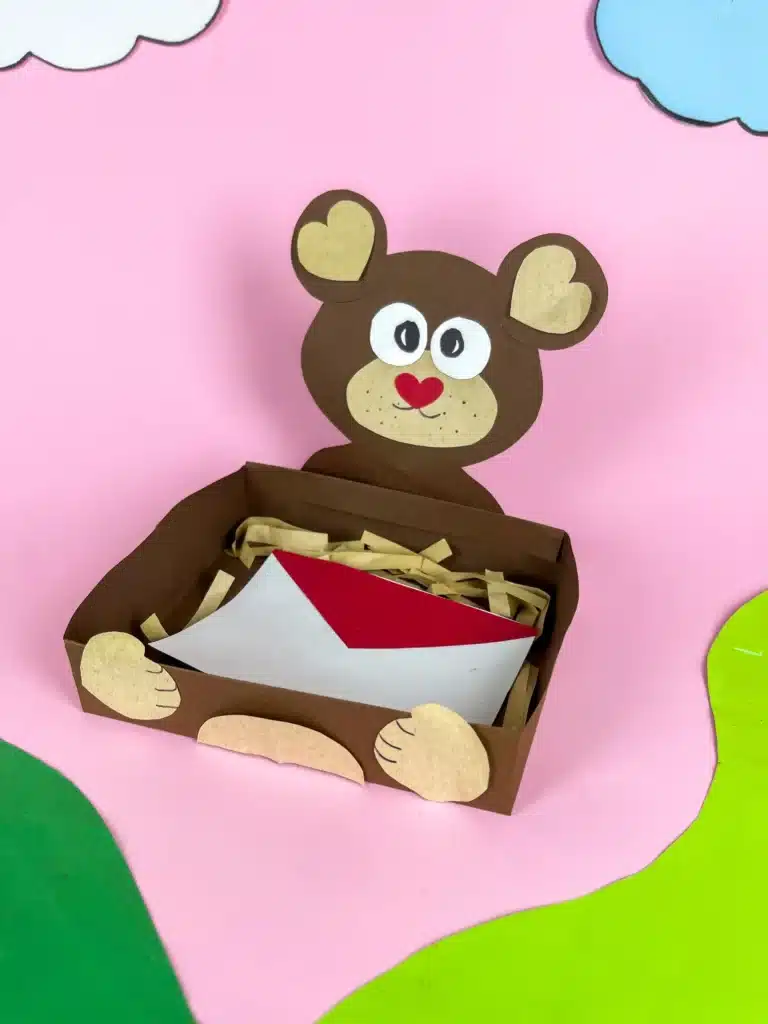 Bear Valentines Box - Cultivating Brilliant Minds a bear valentines box that has a box wrapped in brown paper and a bear head and arms made out of construction paper