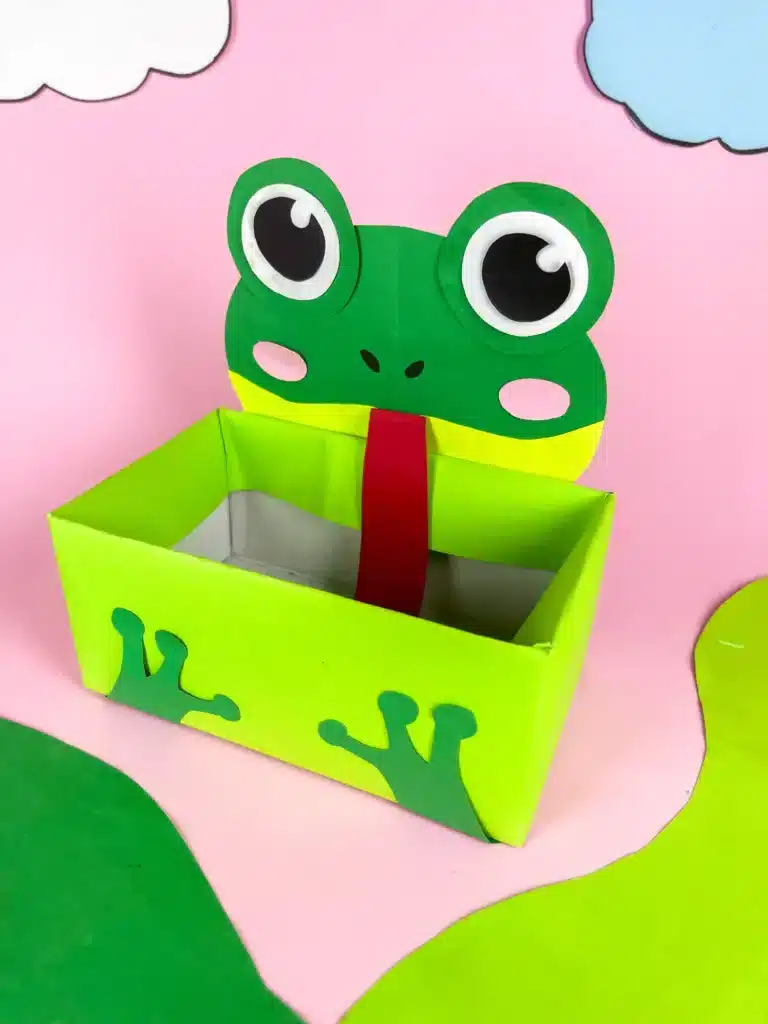 Frog Valentine Box - Cultivating Brilliant Minds a frog valentine box covered with green paper with a construction paper face and legs