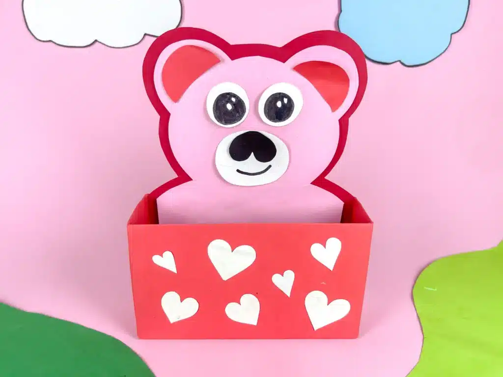 Love Bear Valentine Box - Cultivating Brilliant Minds love bear valentine box: a box covered in red paper with white hearts and a construction paper bear taped inside sticking out of the box