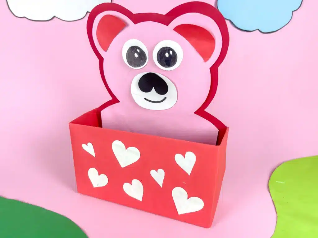 Love Bear Valentine Box - Cultivating Brilliant Minds love bear valentine box: a box covered in red paper with white hearts and a construction paper bear taped inside sticking out of the box
