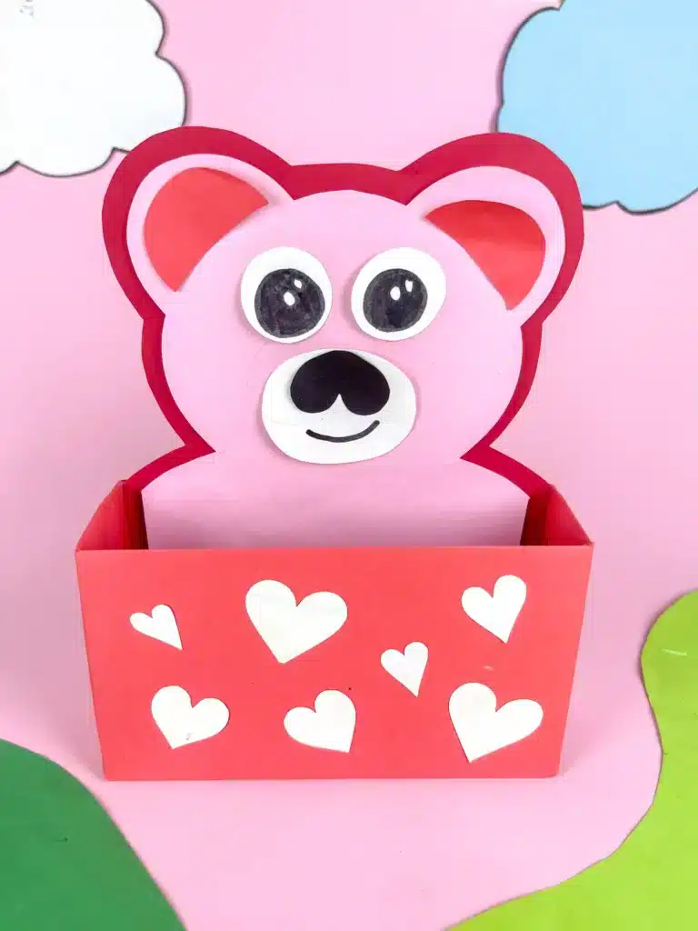 Love Bear Valentine Box - Cultivating Brilliant Minds love bear valentines box: a box covered in red paper with white hearts and a construction paper bear taped inside sticking out of the box