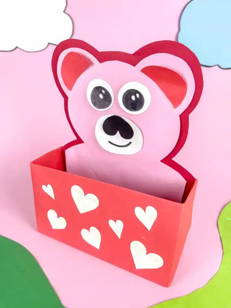 Love Bear Valentine Box - Cultivating Brilliant Minds love bear valentine box: a box covered in red paper with white hearts and a construction paper bear taped inside sticking out of the box