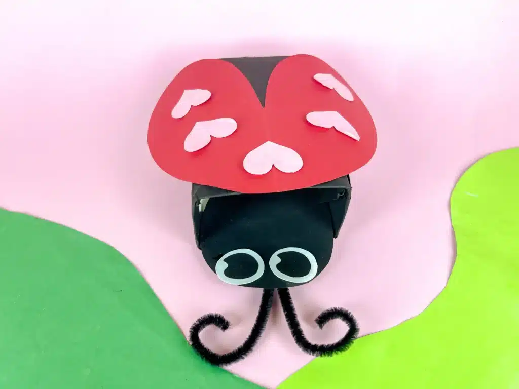 Ladybug Valentines Box - Cultivating Brilliant Minds a ladybug valentines box that has a box covered in black paper with a construction paper ladybug head and construction paper wings with hearts