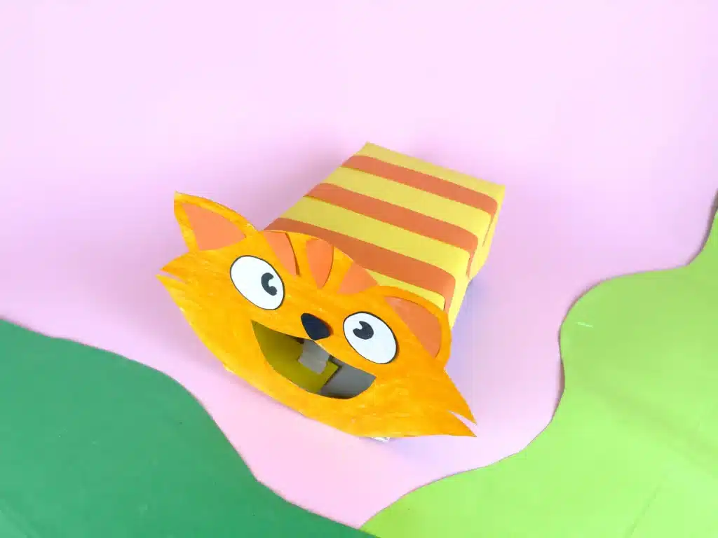 Cat Valentine Box - Cultivating Brilliant Minds a box covered in yellow and orange construction paper to be stripes with a cat face made out of construction paper attached to the front with a hole for the cat's mouth for valentines