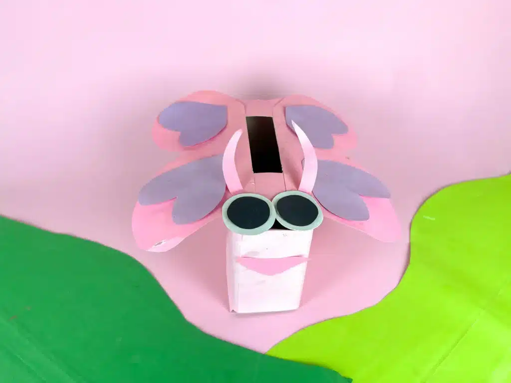 Butterfly Valentines Box - Cultivating Brilliant Minds a butterfly valentines box that has a box wrapped in pink paper with a construction paper face and wings