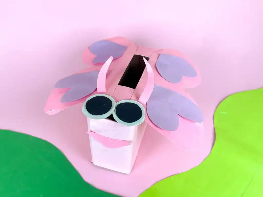 Butterfly Valentines Box - Cultivating Brilliant Minds a butterfly valentines box that has a box wrapped in pink paper with a construction paper face and wings