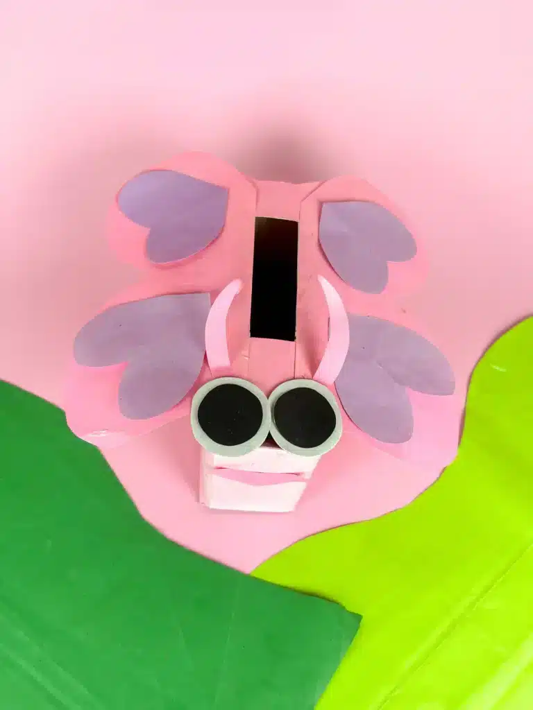 Butterfly Valentines Box - Cultivating Brilliant Minds a butterfly valentines box that has a box wrapped in pink paper with a construction paper face and wings