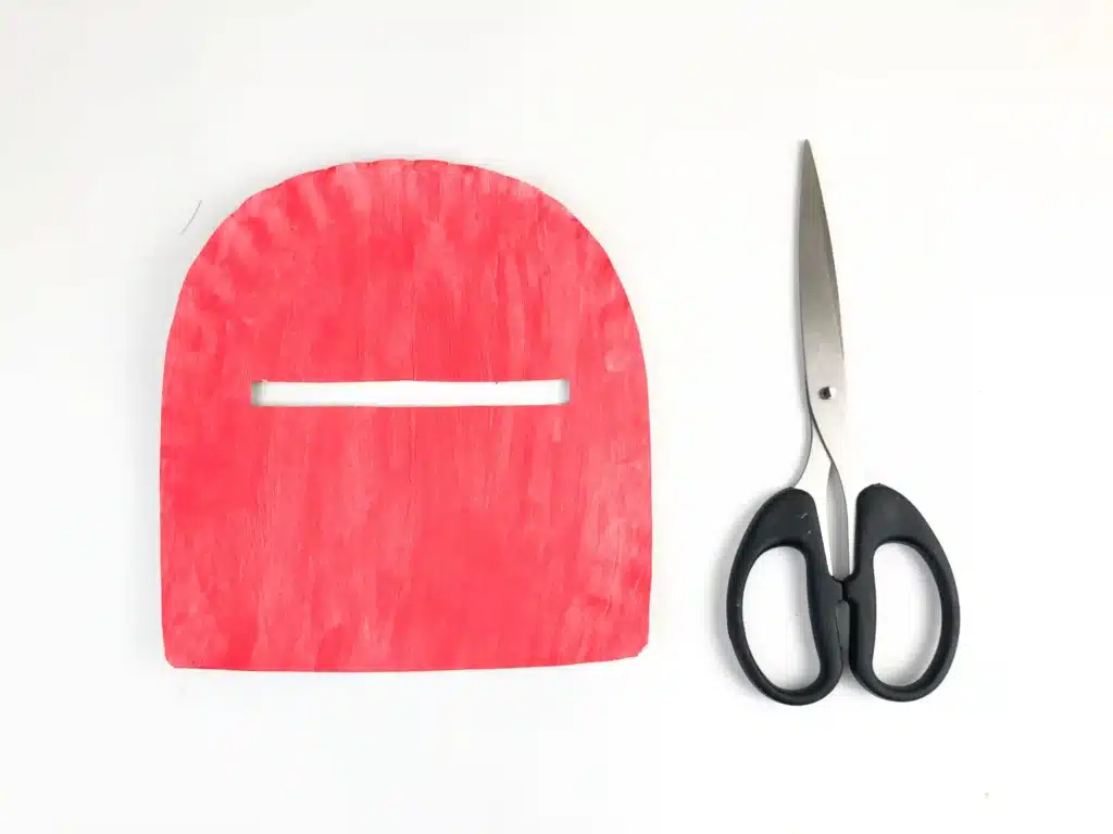 Valentine's Day Mailbox Paper Plate Craft - Cultivating Brilliant Minds a paper plate painted a pink-red color and cut into the shape of a mailbox with a slot cut out for mail