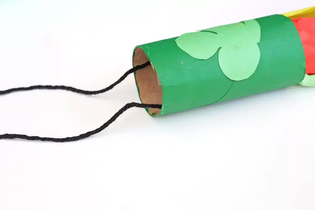 St. Patrick's Day Rainbow Toilet Paper Roll Streamer - Cultivating Brilliant Minds a toilet paper roll painted green with a green shamrock made out construction paper on it and black string taped to the inside to hang