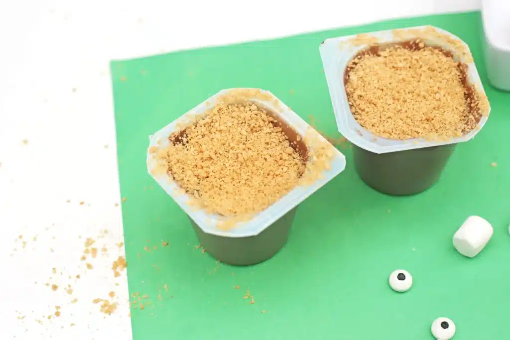 Groundhog Pudding Cups - Cultivating Brilliant Minds pudding cups with grounded up nutter butters sprinkled on top