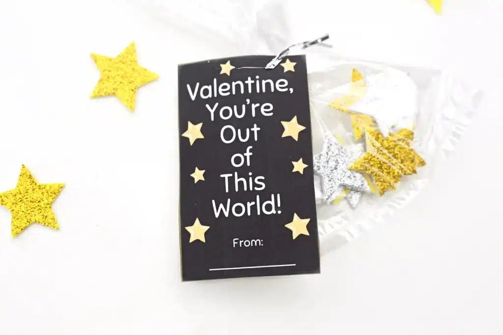 Printable Valentine You're Out of This World - Cultivating Brilliant Minds a printable valentine that reads "valentine, you're out of this word!" attached to a bag of foam stars