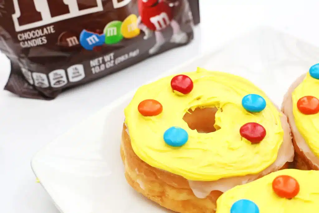 Dr. Seuss Put Me in the Zoo Donuts - Cultivating Brilliant Minds glazed donuts with yellow icing and red and blue m&ms on top